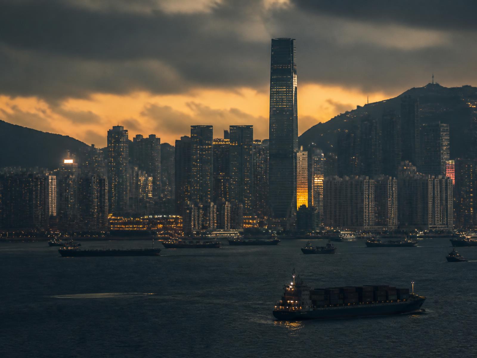Puerto y skyline de Hong Kong con buques portacontenedores al atardecer